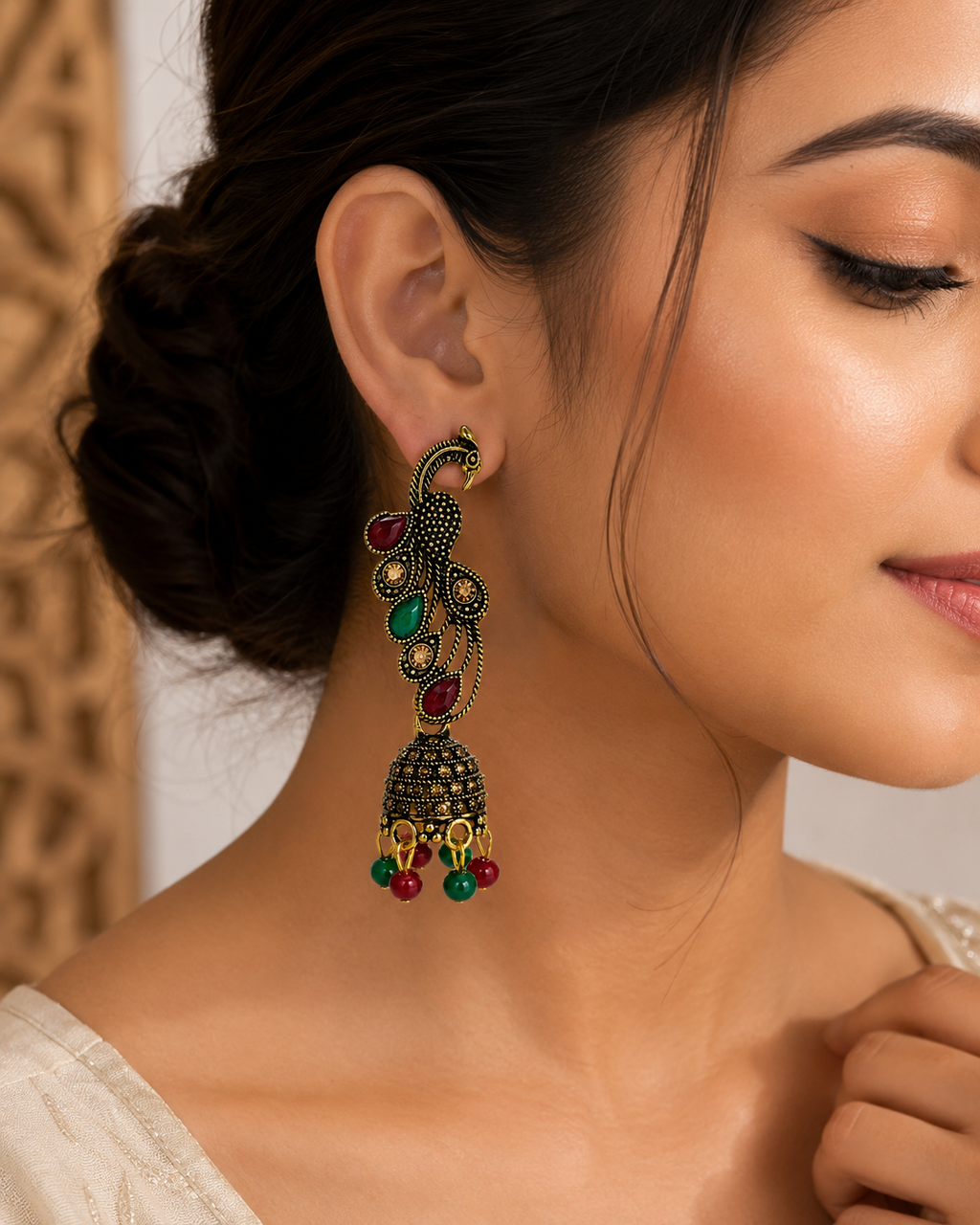 Model wearing antique gold peacock jhumka earring
