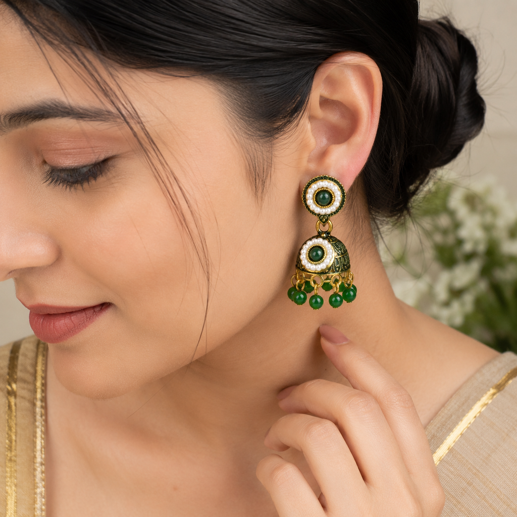 Model wearing green and gold jhumka earring